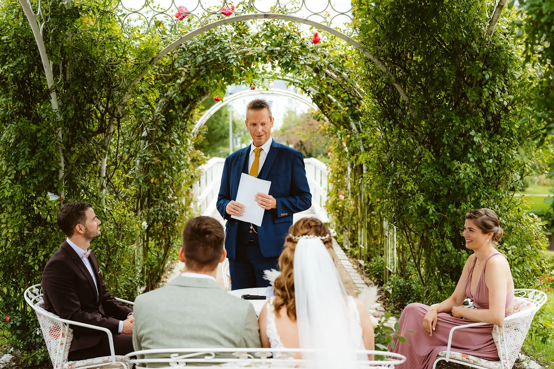 Rosarium Uetersen, Standesbeamter steht auf der Hochzeitsinsel im Rosarium und redet zum Brautpaar.