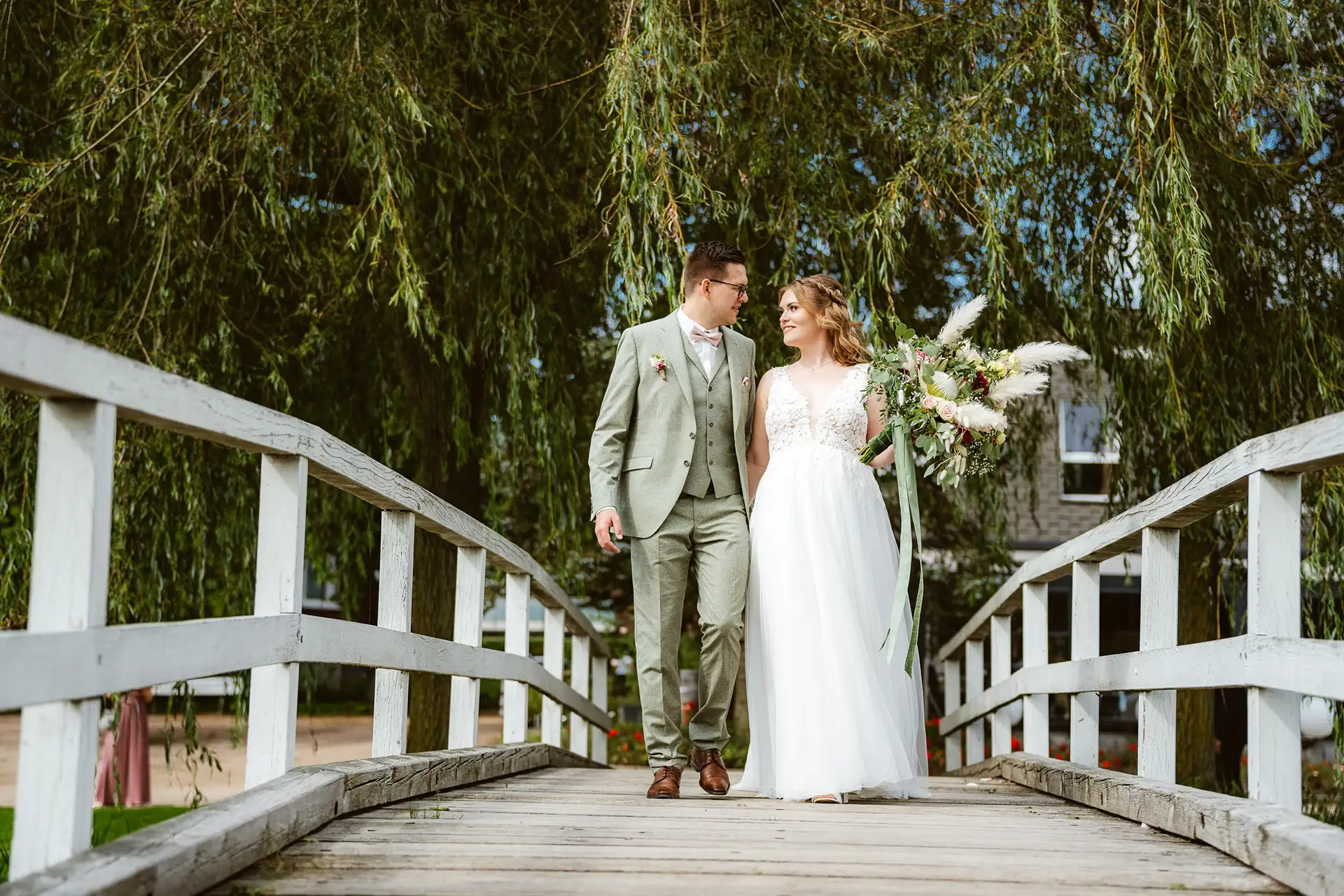 Rosarium Uetersen, Hochzeitsinsel, Brautpaar geht über die weiße Brücke zur Trauung.